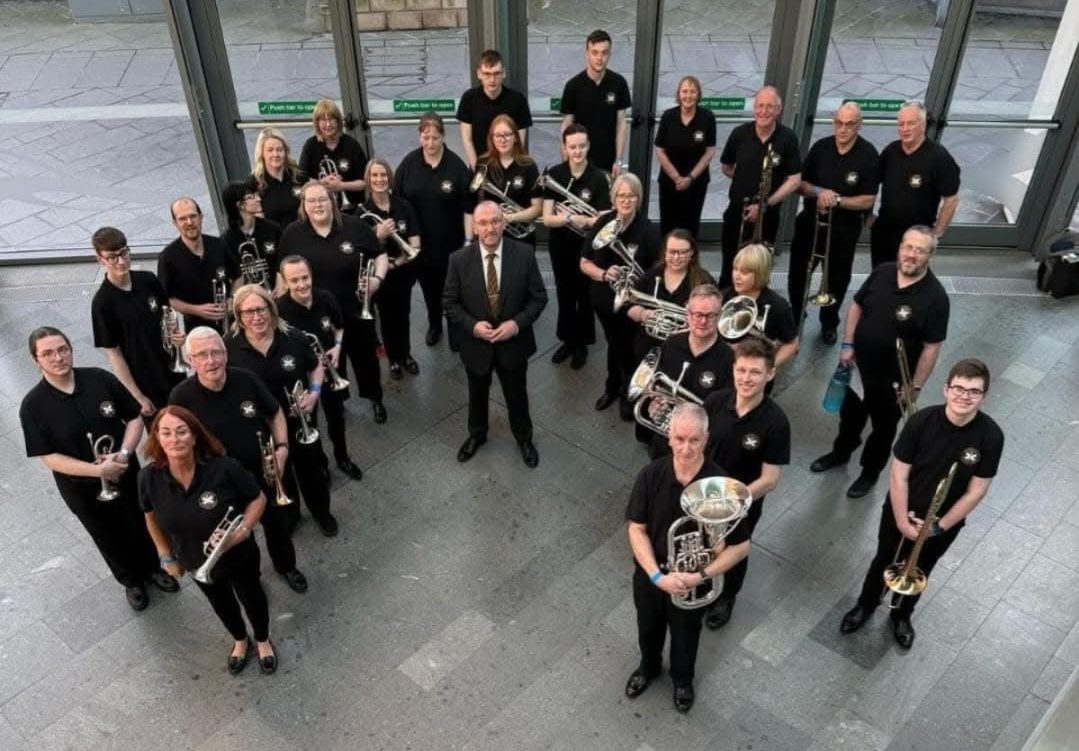 Members of a Brass Band looking up towards the camera