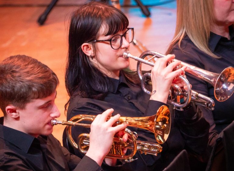 Two females holding brass instruments